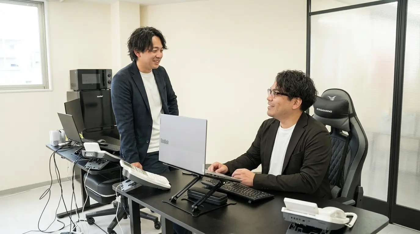 デスクのそばで相談する社員